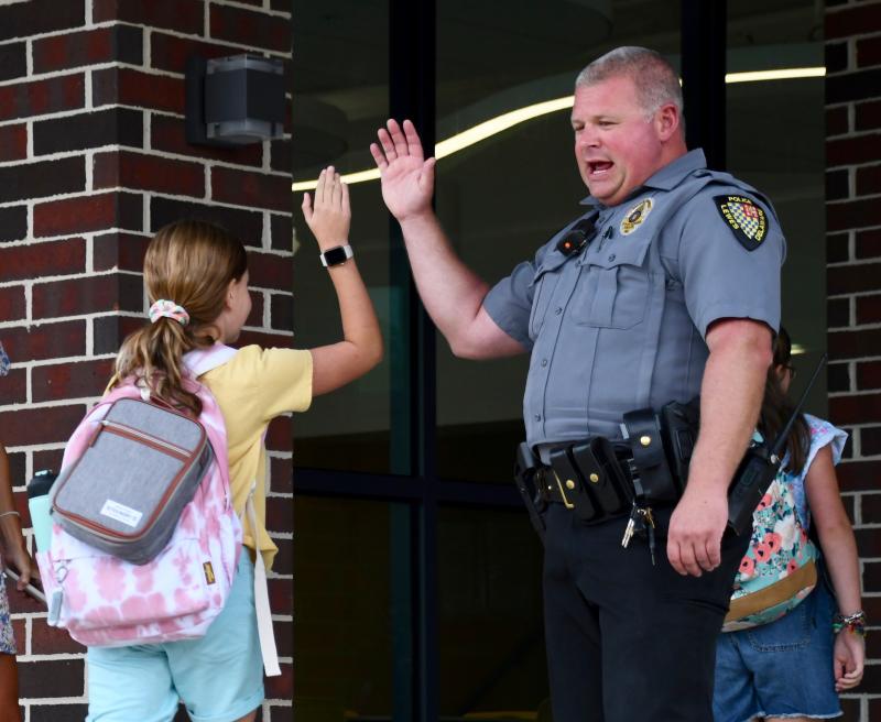 Lewes Police Officer Chatham Marsch gives high-fives to Lewes Elementary School students as they begin the first day of school. RON MACARTHUR PHOTO